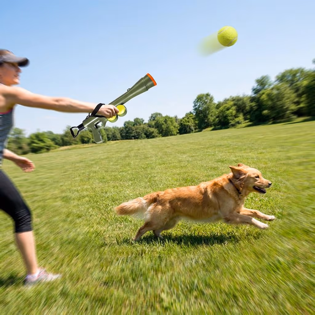 Person throwing a tennis ball long distance using the launcher in a park